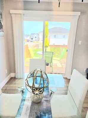 A room with a glass table, a white chair, and a decorative globe centerpiece.