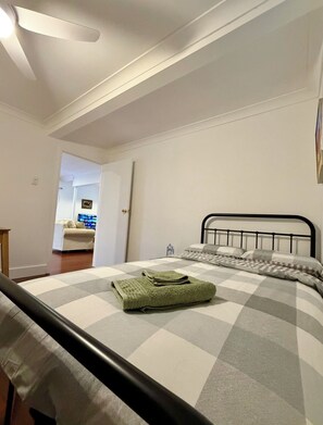 A bedroom with a bed, a door, and a view into another room. - Tranquility close to the river (Chelmer)
