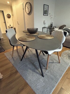 A dining area with a round table, chairs, and a clock on the wall. - Vrbo Property (Vettweiss)
