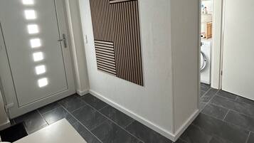Ein Zimmer mit einer weißen Tür, einem weißen Tisch und einem Wandlüfter.