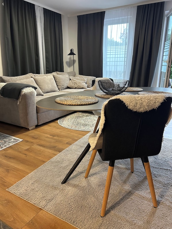 A modern living room with a grey sofa, a black chair, and a round coffee table.
