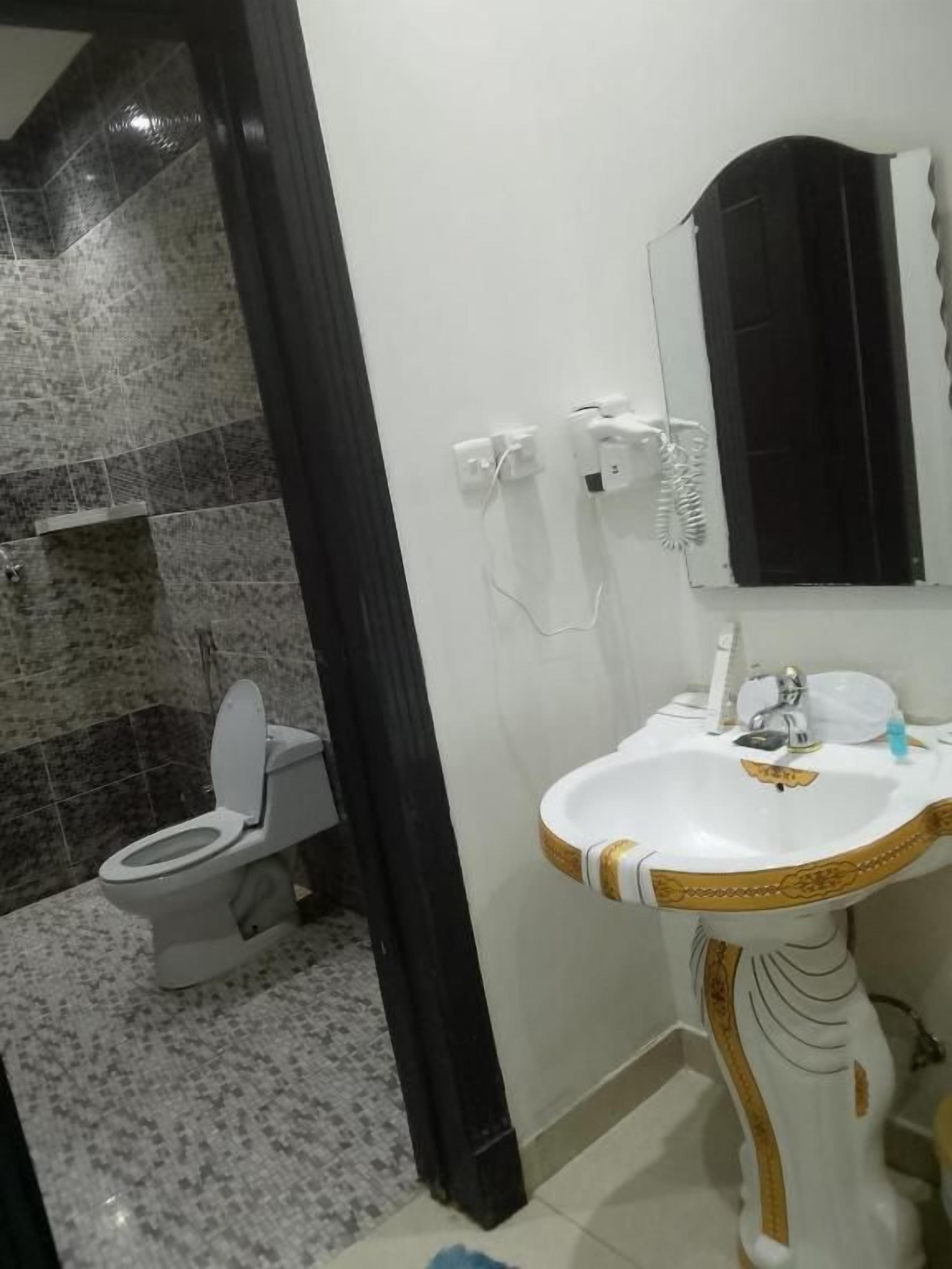 Un baño con inodoro, lavabo y espejo.