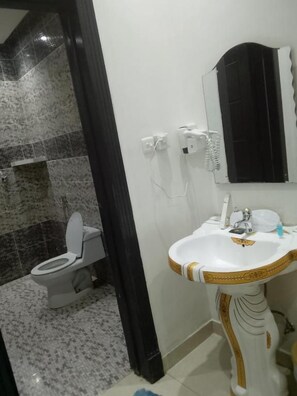 Un baño con inodoro, lavabo y espejo.