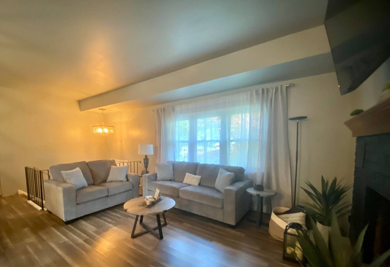A living room with two sofas, a coffee table, and a fireplace.