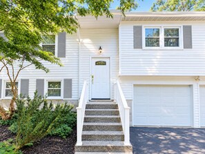A two-story house with a front door, a staircase, and a garage.
