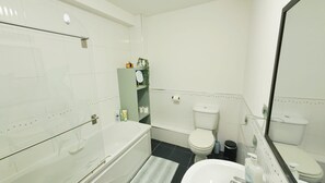 A modern bathroom with a bathtub, toilet, and sink. - The Galway Getaway-Spacious family room/Perfect to Explore the Wonders of Galway (Galway)