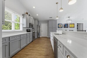 A modern kitchen with grey cabinets, a white countertop, and a wooden floor. - Lake Front Retreat with Private 2-Story Dock (Estill Springs)