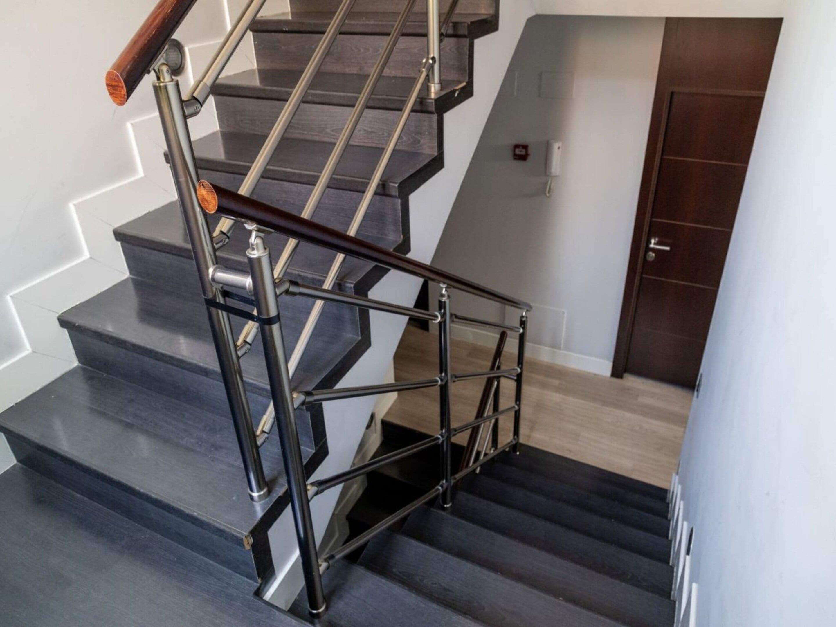 A staircase with a metal handrail and wooden steps.