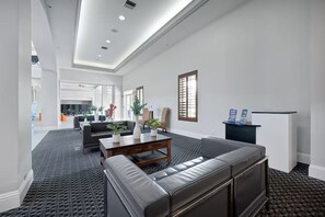 A spacious living area with a leather sofa, a coffee table, and a fireplace. - Suites at Lake Buena Vista close Disney Spring (Orlando)