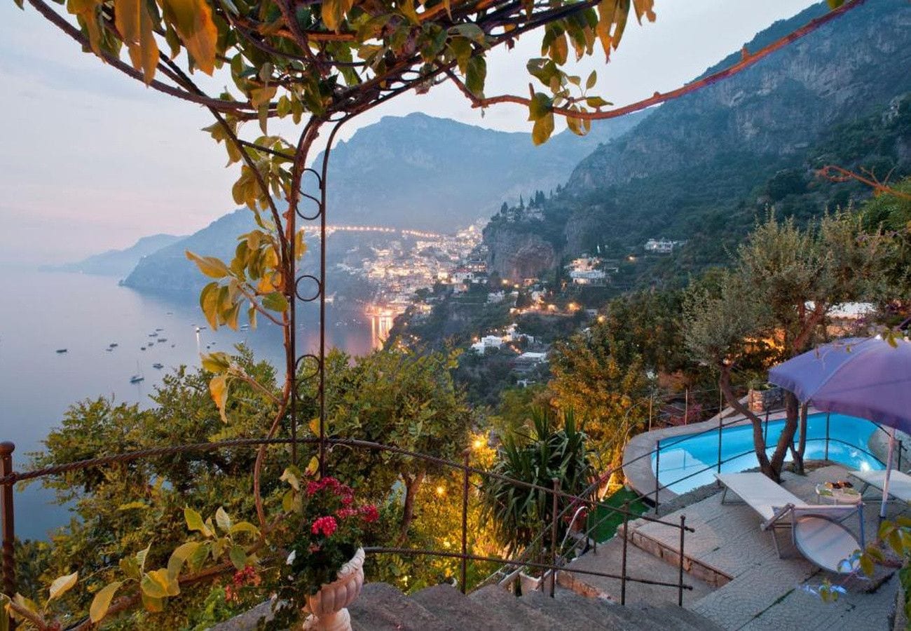 Zona de piscina con vistas a un paisaje montañoso y un cuerpo de agua.