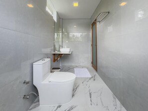A modern bathroom with a toilet, sink, and shower. - Lagoon Villa Maldives (Aa.Thoddoo)