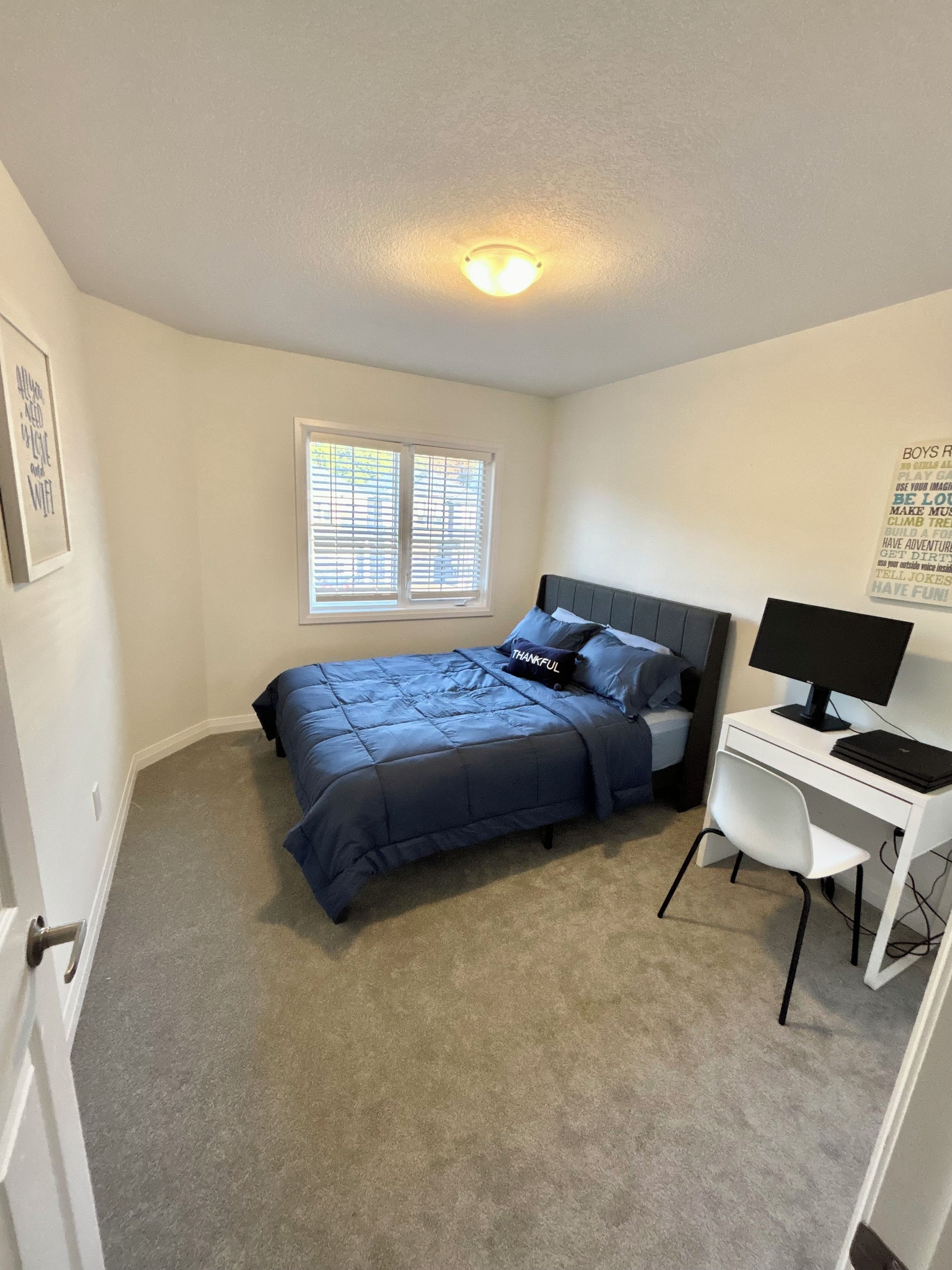 Une chambre à coucher avec un lit, un bureau et une fenêtre.