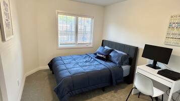 Une chambre à coucher avec un lit, un bureau et une fenêtre.