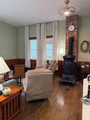 Un salon chaleureux avec un canapé en cuir, une table basse en bois, une cheminée en pierre et un mur en briques.