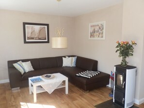 Ein Wohnzimmer mit einem braunen Sofa, einem weißen Couchtisch, einem Kamin und einem gerahmten Bild an der Wand.