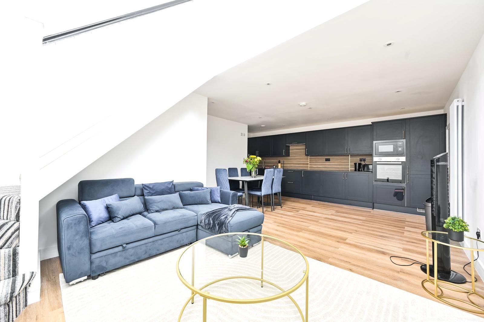 Un espacio habitable moderno con sofá, mesa de centro y comedor.