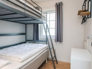 A bunk bed with a ladder, a window with curtains, and a white dresser. - 4 Person Holiday Home in Laeso (Læsø)