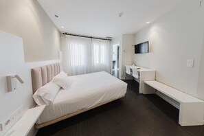 Una camera da letto moderna con un letto, un comodino, una panca e una TV a parete.