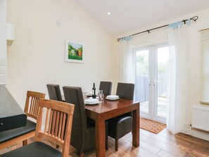 A dining area with a wooden table, chairs, and a painting on the wall. - Bramble (Cleator)