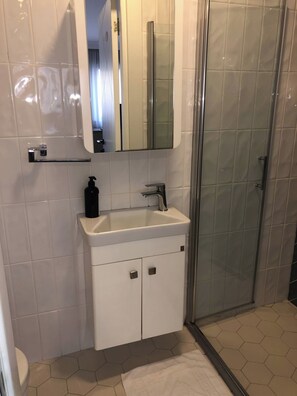A bathroom with a white sink, a mirror, and a shower enclosure. - Rich Area In Istanbul Suite 4 (Istanbul)