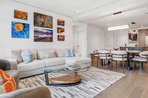 A modern living room with a sofa, coffee table, and artwork on the wall. - Frontgate 306 - 2 Bedroom + Office (Avon)