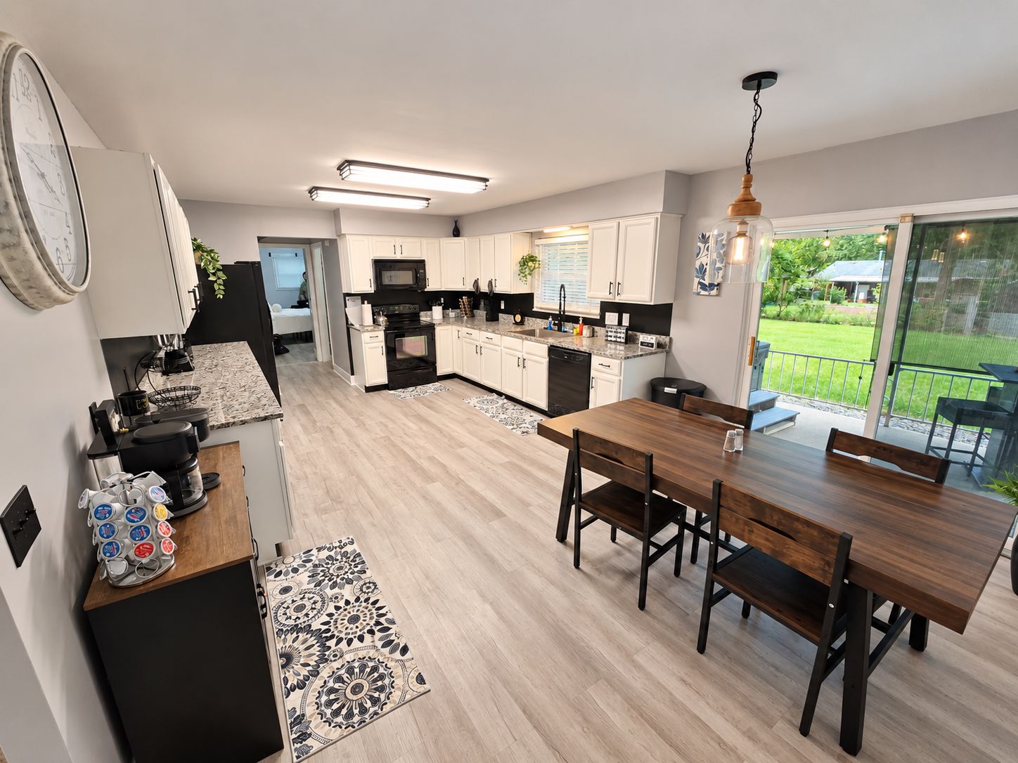 A modern kitchen with a dining area, a large window, and a view of the outdoors.