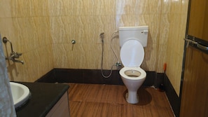A bathroom with a toilet, a sink, and a shower. - Midguard Beach Resort (Morjim)