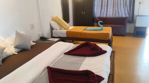 A hotel room with two beds, a sofa, a TV, and a wardrobe. - Midguard Beach Resort (Morjim)