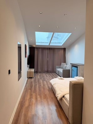 A modern hotel room with a skylight, a sofa, a bed, and a small cabinet. - Rich Area In Istanbul Residence 4 (Istanbul)
