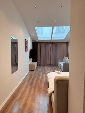 A modern bedroom with a skylight, a sofa, a bed, and a small bedside table. - Rich Area In Istanbul Residence 4 (Istanbul)
