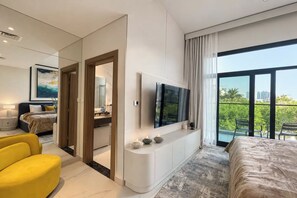 Ein modernes Hotelzimmer mit einem großen Bett, einem Fernseher, einem Balkon mit Aussicht und einem gelben Sessel.