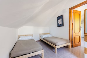 Een kleine, eenpersoons accommodatie met twee houten stapelbedden, een kunstwerk in een lijst aan de muur en een houten deur.