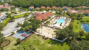 A residential area with a swimming pool, tennis courts, and a parking lot. - Prime Location Bella Vida Pool Retreat Near Disney (Kissimmee)