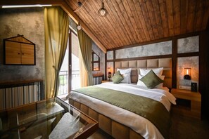 A bedroom with a large bed, wooden headboard, bedside tables, and a glass table.
