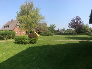 A residential area with a grassy lawn, a playground with a slide, and a house with a chimney. - Little Baked Apple (Wrixum)