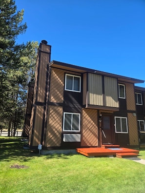 A two-story building with a brown exterior, a chimney, and a small front porch. - Yellowstone Gathering Place (West Yellowstone)