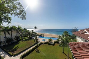 A resort with a pool, beach, and ocean view. - Luxury Beachfront Apartment in Sosua! (Sosúa)