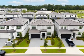 A residential area with modern houses, each with a garage and a small front yard. - 8BR Villa Avengers Game Room + Pool Disney (Orlando)