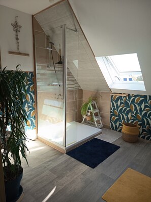 A modern loft bedroom with a glass staircase, a skylight, and a view of the outside. - Apartment in a typical village in Finistère. (Plogoff)
