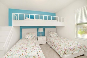 A bedroom with a bunk bed, two single beds, a nightstand, and a window with blinds. - Luxury Home at Solterra Resort (Davenport)