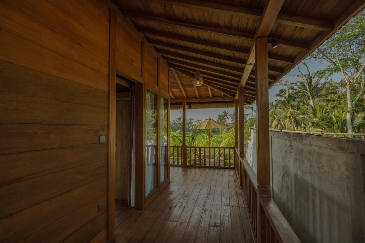 Ein Holzbalkon mit Blick auf üppige tropische Vegetation.
