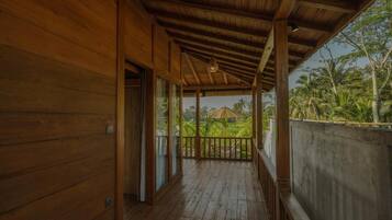 Ein Holzbalkon mit Blick auf üppige tropische Vegetation.