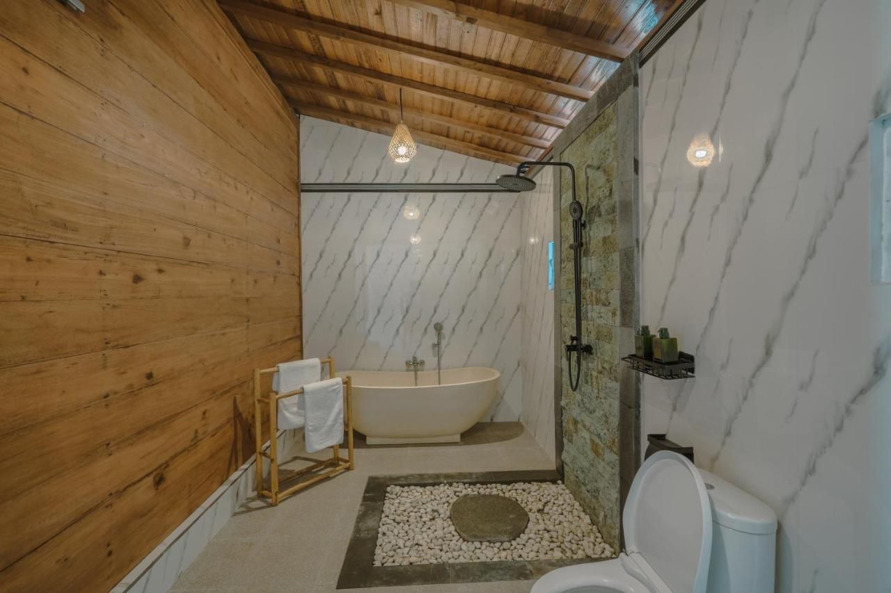 Une salle de bain avec une baignoire sur pieds, un espace douche et des toilettes.