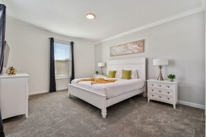 A bedroom with a white bed, two nightstands, a white dresser, a window with curtains, and a ceiling light. - 5BR Storey Lake Home, Pool & Game Room (Kissimmee)