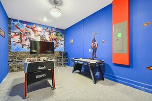 A room with a foosball table, a pool table, and a TV mounted on the wall. - 5BR Storey Lake Home, Pool & Game Room (Kissimmee)