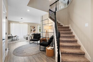 A spacious living area with a staircase, a sofa set, a coffee table, and a lamp. - Reunion 4BR Luxury Villa PS5 + Game Room (Kissimmee)