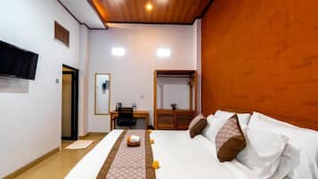 Ein Hotelzimmer mit Bett, Schreibtisch, Stuhl, Fernseher und Spiegel.