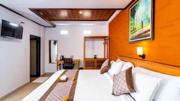 Ein Hotelzimmer mit Bett, Schreibtisch, Stuhl, Fernseher und einem Gemälde an der Wand.