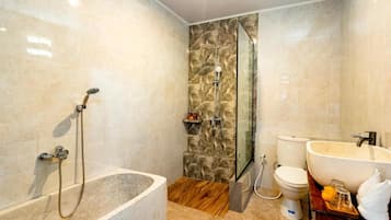Une salle de bain moderne avec une baignoire sur pieds, une douche à parois de verre, des toilettes et un lavabo doté d’un grand bac.