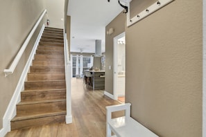 A wooden staircase leading to a kitchen area with a dining table and chairs. - Windsor Hills 3BR Pool,8min to Disney & Water Park (Kissimmee)